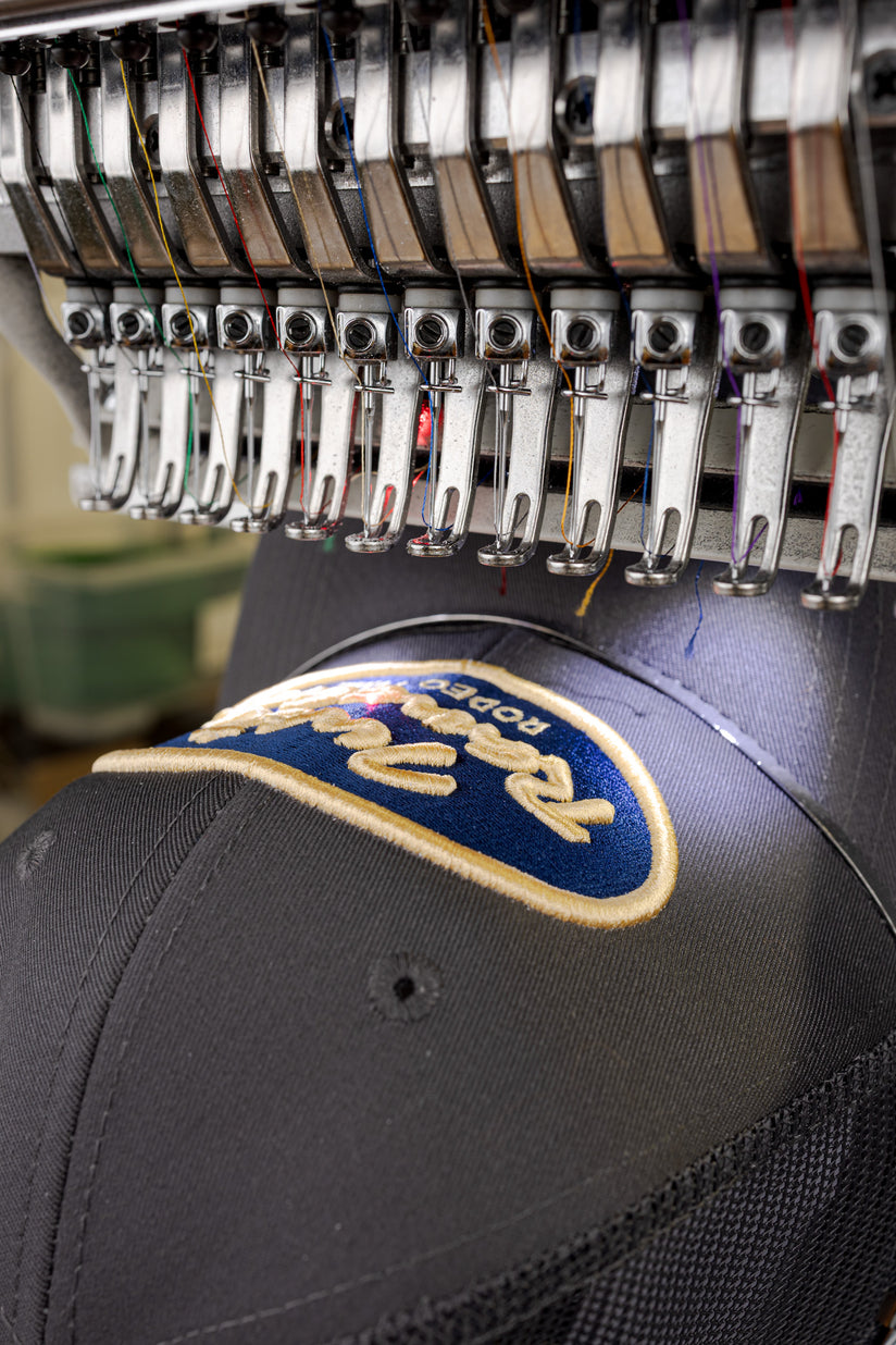 Custom embroidery machine stitching a logo on a cap
